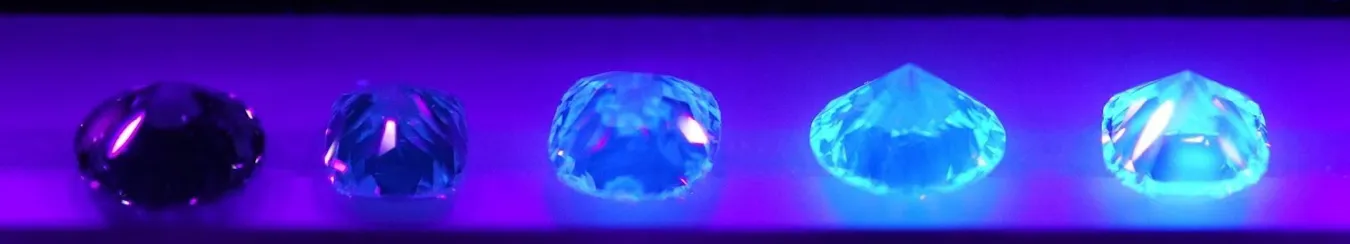 ブラックライト下における、蛍光性ごとのダイヤモンドの見え方を示した写真