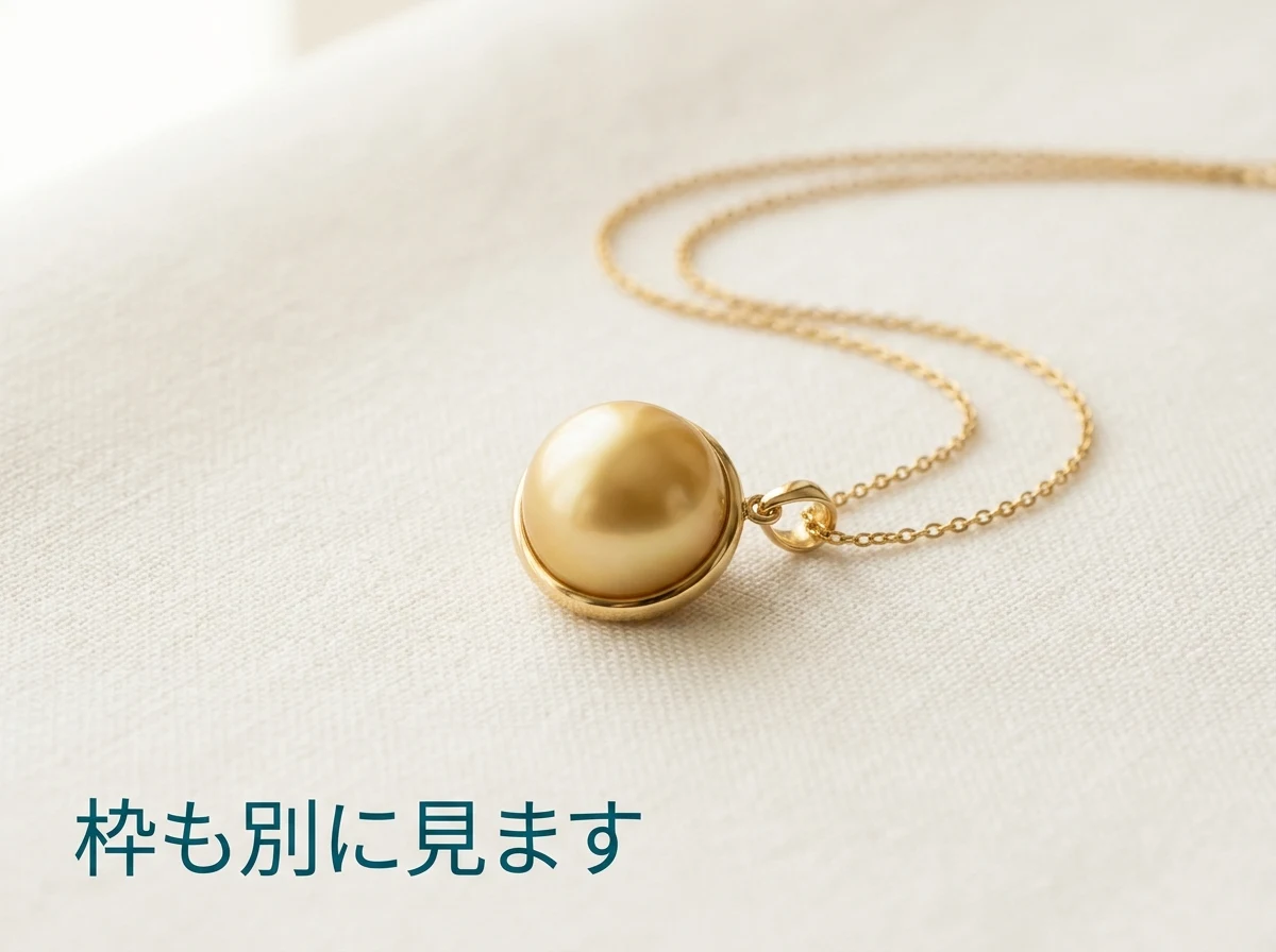 金の枠に留められた金色の真珠のペンダントを布の上に置いた写真