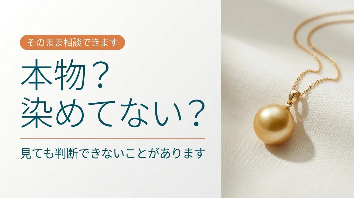 金色の真珠のペンダントを布の上に置いた写真