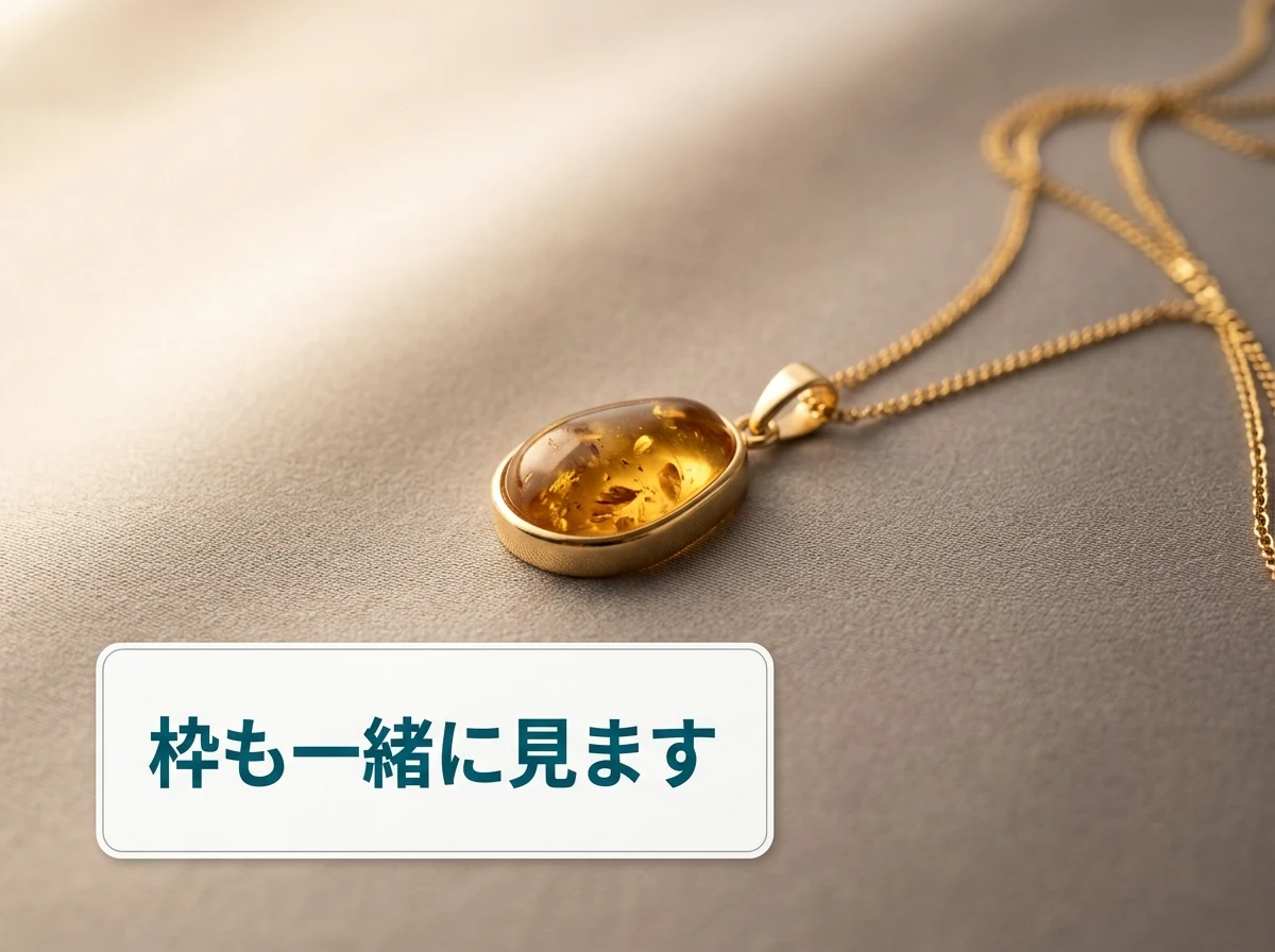 金具の付いた琥珀のペンダントを布の上に置いた写真