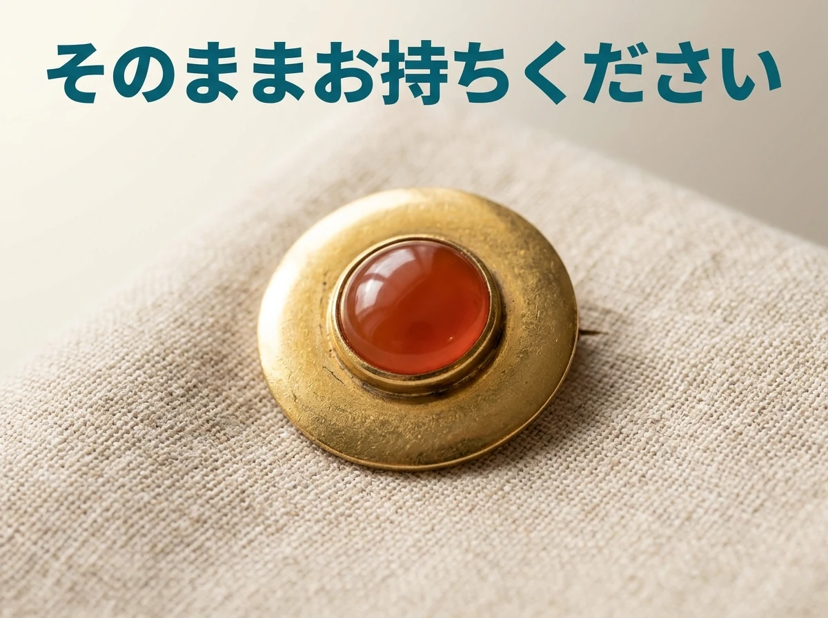 生成りの布の上に置いた、カーネリアンのブローチの写真