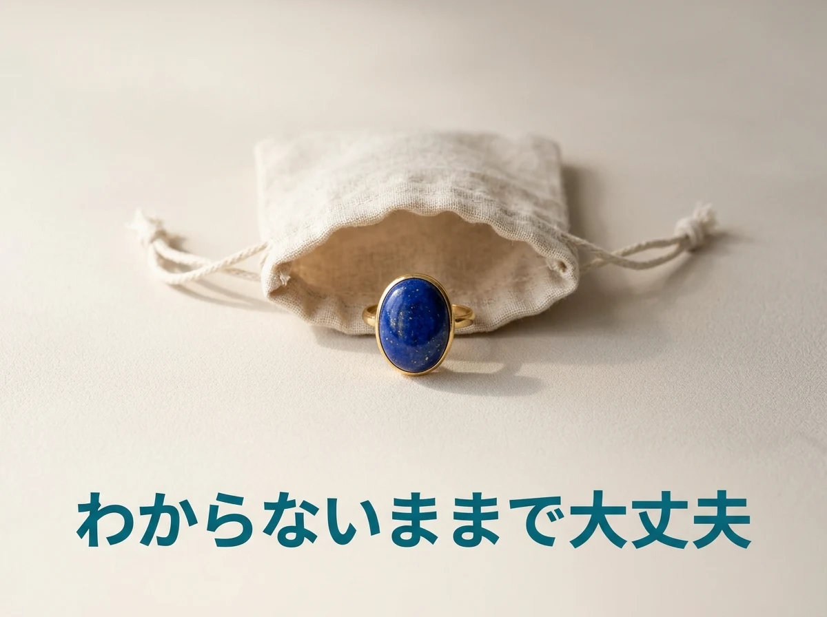 口を開いた無地のリネンの巾着の前に置いた、金色の枠に濃い青のラピスラズリを留めた指輪の写真。本物かわからないままでも見せてよいことを示している。画像内の文字は「わからないままで大丈夫」